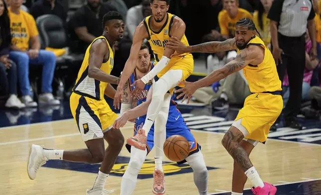 Oklahoma City Thunder center Isaiah Hartenstein passes around Indiana Pacers guard Tyrese Haliburton, right, during the second half of Game 3 of the NBA Finals basketball series, Wednesday, June 11, 2025, in Indianapolis. (AP Photo/Abbie Parr)