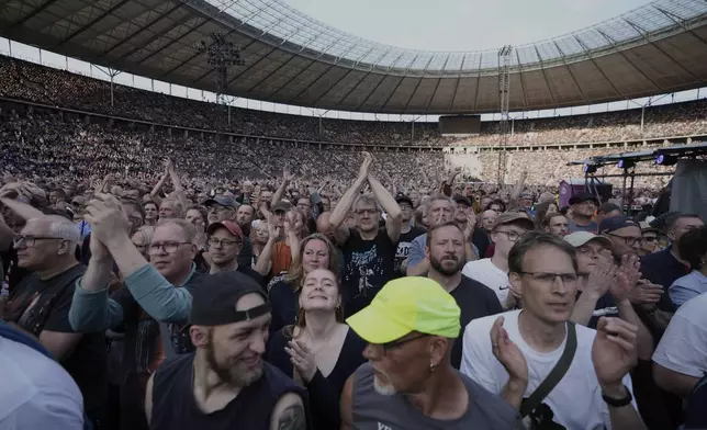 Spectators watch Bruce Springsteen and the E Street Band perform at the Olympic Stadium, in Berlin, Germany, Wednesday, June 11, 2025. (AP Photo/Markus Schreiber)