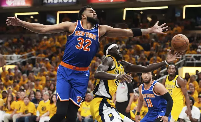 New York Knicks center Karl-Anthony Towns (32) and Indiana Pacers forward Pascal Siakam (43) reach for the ball during the first half of Game 6 of the Eastern Conference finals of the NBA basketball playoffs in Indianapolis, Saturday, May 31, 2025. (AP Photo/Michael Conroy)