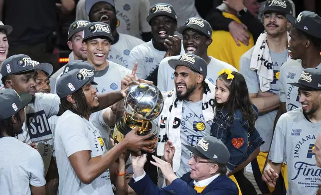 Indiana Pacers players celebrate with the trophy after winning Game 6 of the Eastern Conference finals of the NBA basketball playoffs against the New York Knicks in Indianapolis, Saturday, May 31, 2025. (AP Photo/AJ Mast)