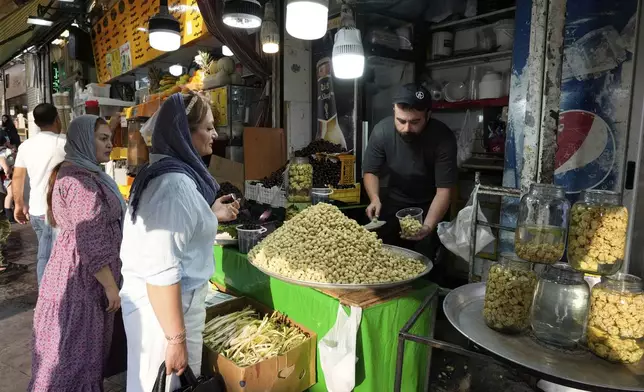 A fruit seller sells Mulberry at Tajrish traditional bazaar in northern Tehran, Iran, Friday, June 13, 2025. (AP Photo/Vahid Salemi)