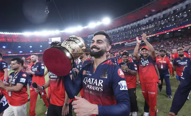 Royal Challengers Bengaluru's Virat Kohli celebrates with the winners trophy after their win in the Indian Premier League final cricket match against Punjab Kings at Narendra Modi Stadium in Ahmedabad, India, Wednesday, June 4, 2025. (AP Photo/Ajit Solanki)