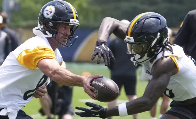 Pittsburgh Steelers quarterback Aaron Rodgers, left hands off to running back Kaleb Johnson during practice at NFL football minicamp, Tuesday, June 10, 2025, in Pittsburgh. (AP Photo/Gene J. Puskar)