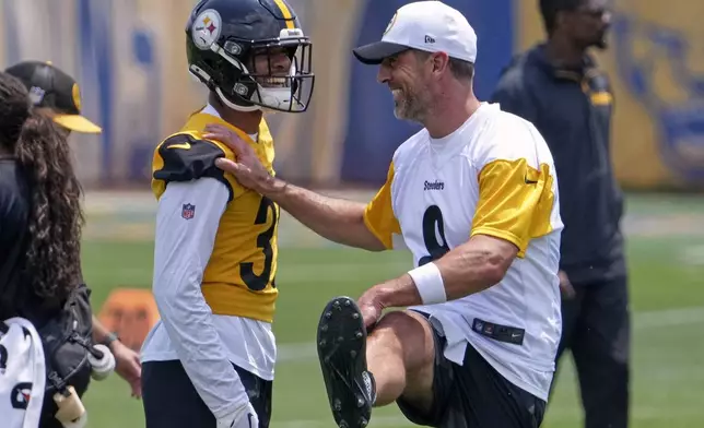 Pittsburgh Steelers quarterback Aaron Rodgers, right, and safety Quindell Johnson stretch during practice at NFL football minicamp, Tuesday, June 10, 2025, in Pittsburgh. (AP Photo/Gene J. Puskar)