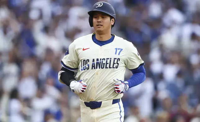 Los Angeles Dodgers designated hitter Shohei Ohtani runs towards home plate after hitting a home run during the first inning of a baseball game against the San Francisco Giants in Los Angeles, Saturday, June 14, 2025. (AP Photo/Jessie Alcheh)