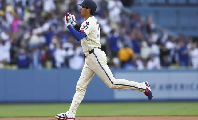 Los Angeles Dodgers designated hitter Shohei Ohtani gestures while running the bases after hitting a home run during the first inning inning of a baseball game against the San Francisco Giants in Los Angeles, Saturday, June 14, 2025. (AP Photo/Jessie Alcheh)