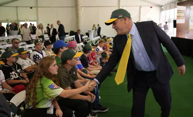 Athletics owner John Fisher, right, meets with people during a groundbreaking ceremony for the Athletics' baseball stadium Monday, June 23, 2025, in Las Vegas. (AP Photo/John Locher)