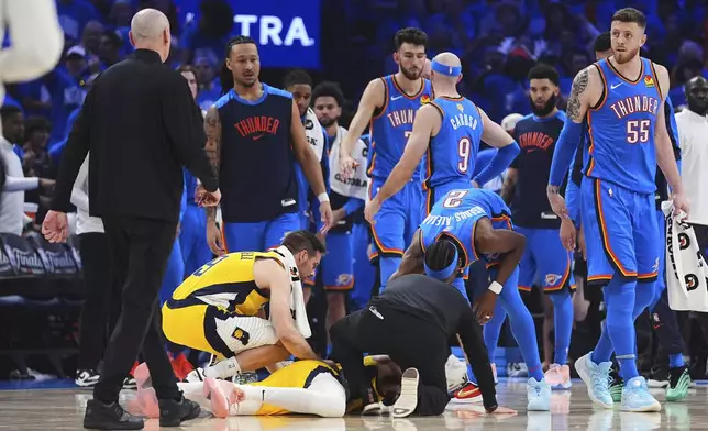 Indiana Pacers guard Tyrese Haliburton, center, lays on the court after an injury during the first half of Game 7 of the NBA Finals basketball series against the Oklahoma City Thunder Sunday, June 22, 2025, in Oklahoma City. (AP Photo/Julio Cortez)