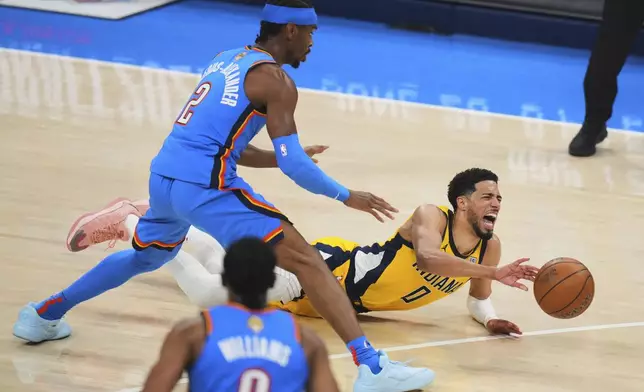 Indiana Pacers guard Tyrese Haliburton (0) falls to the court with an injury during the first half of Game 7 of the NBA Finals basketball series against the Oklahoma City Thunder Sunday, June 22, 2025, in Oklahoma City. (AP Photo/Nate Billings)