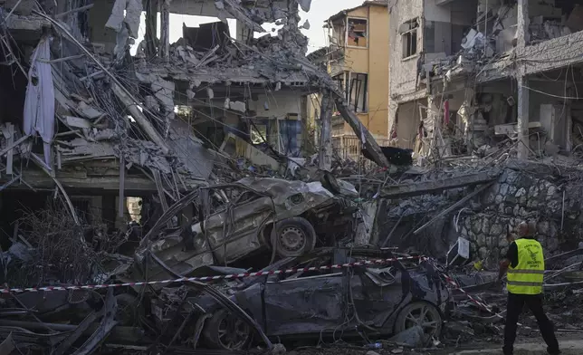 Israeli security forces inspect destroyed residential buildings that were hit by a missile fired from Iran, in Ramat Gan, near Tel Aviv, Israel, on Saturday, June 14, 2025. (AP Photo/Ariel Schalit)