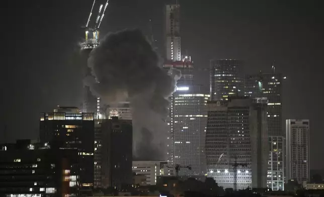 Smoke billows after a projectile hit a building in Tel Aviv, Israel, early Saturday, June 14, 2025. (AP Photo/Leo Correa)