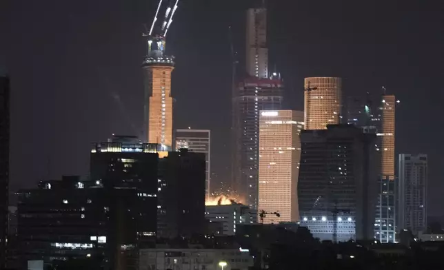 A projectile hits a building in Tel Aviv, Israel, early Saturday, June 14, 2025. (AP Photo/Leo Correa)