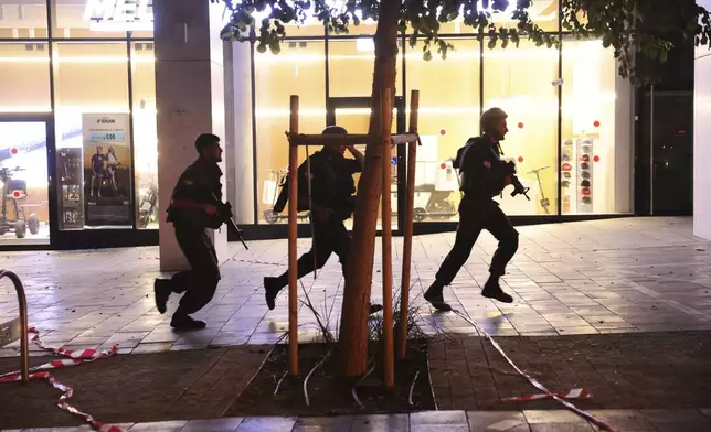 Israeli security forces run to take cover while missiles were launched from Iran towards Israel, in Tel Aviv, Israel, on Friday, June 13, 2025. (AP Photo/Tomer Appelbaum)