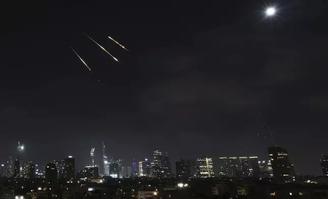 Traces of projectiles are seen over Tel Aviv, Israel, early Saturday, June 14, 2025. (AP Photo/Leo Correa)