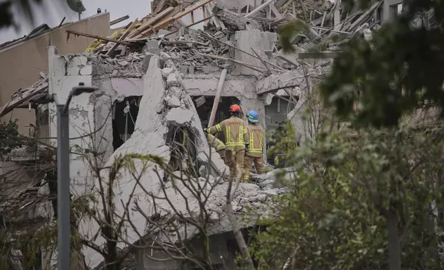 Israeli security forces inspect destroyed houses that were struck by a missile fired from Iran, in Rishon Lezion, Israel on Saturday, June 14, 2025. (AP Photo/Ohad Zwigenberg)