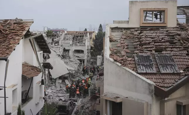 Israeli security forces inspect destroyed houses that were struck by a missile fired from Iran, in Rishon Lezion, Israel on Saturday, June 14, 2025. (AP Photo/Ohad Zwigenberg)