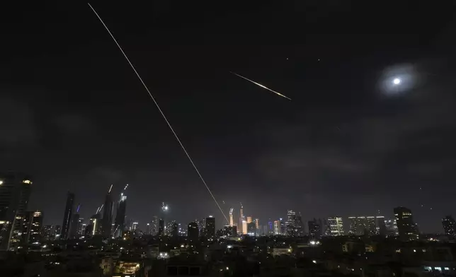 The trace of a projectile is seen as it hits buildings in Tel Aviv, Israel, early Saturday, June 14, 2025. (AP Photo/Leo Correa)