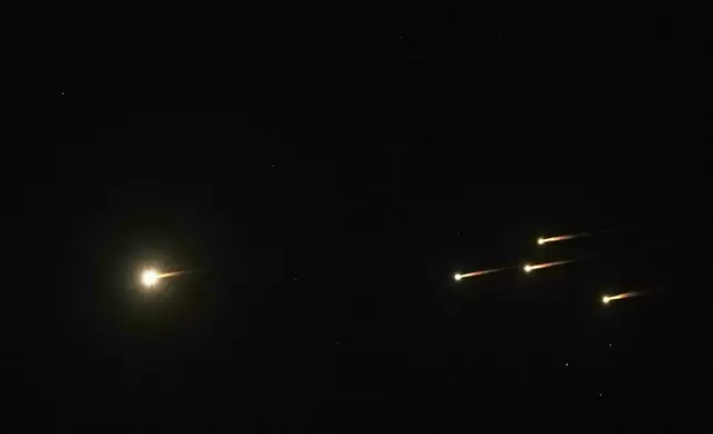 Missiles illuminate the night sky Jerusalem during an Iranian missile attack, Friday, June 13, 2025. (AP Photo/Mahmoud Illean)