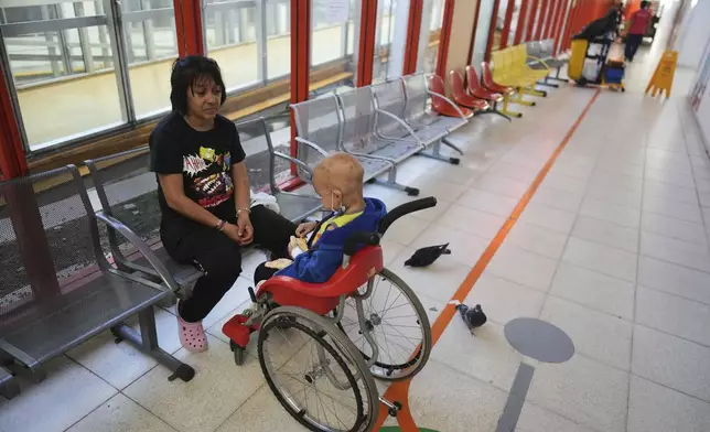 Lucia Ruiz Diaz sits next to her 5-year-old son Tomas, who has cancer, at a waiting room in the Garrahan Hospital in Buenos Aires, Argentina, Tuesday, April 29, 2025. Cancer patients say they’ve grown sicker since Argentina’s libertarian President Javier Milei took his chainsaw to the public health system. (AP Photo/Natacha Pisarenko)
