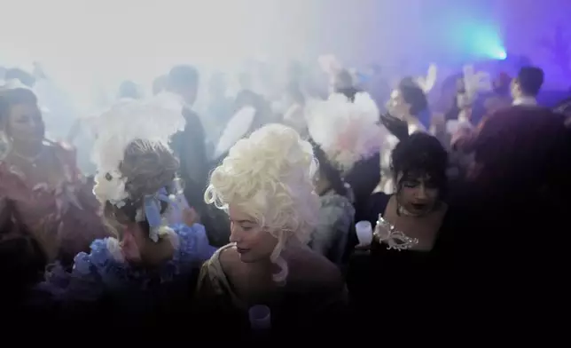 Costumed guests dance during the Great Masked Ball in the Orangerie of the Versailles castle, outside Paris, Sunday, June 22, 2025. (AP Photo/Christophe Ena)