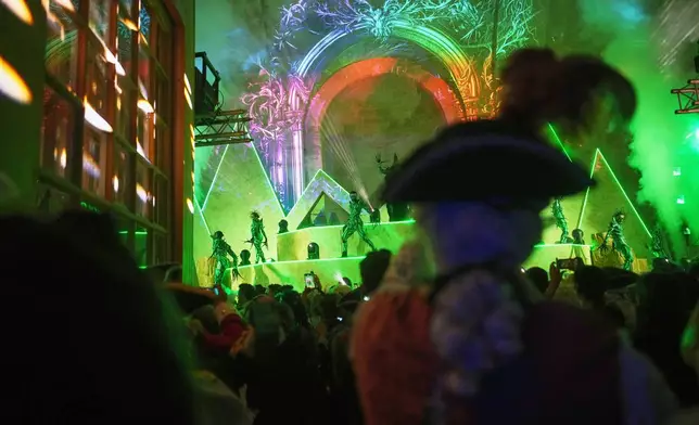 Costumed guests watch performers at the Great Masked Ball in the Orangerie of the Versailles castle, outside Paris, Sunday, June 22. (AP Photo/Christophe Ena)