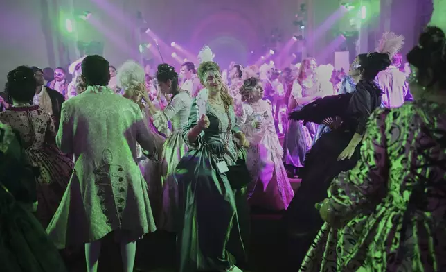 Costumed guests dance at the Great Masked Ball in the Orangerie of the Versailles castle, outside Paris, Sunday, June 22, 2025. (AP Photo/Christophe Ena)