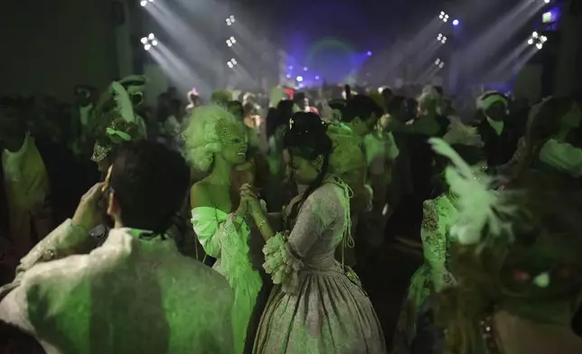 Costumed guests dance at the Great Masked Ball in the Orangerie of the Versailles castle, outside Paris, Sunday, June 22, 2025. (AP Photo/Christophe Ena)