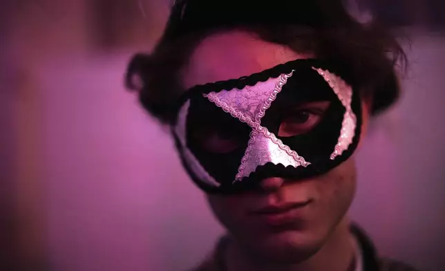 A costumed guest attends the Great Masked Ball in the Orangerie of the Versailles castle, outside Paris, Sunday, June 22, 2025. (AP Photo/Christophe Ena)