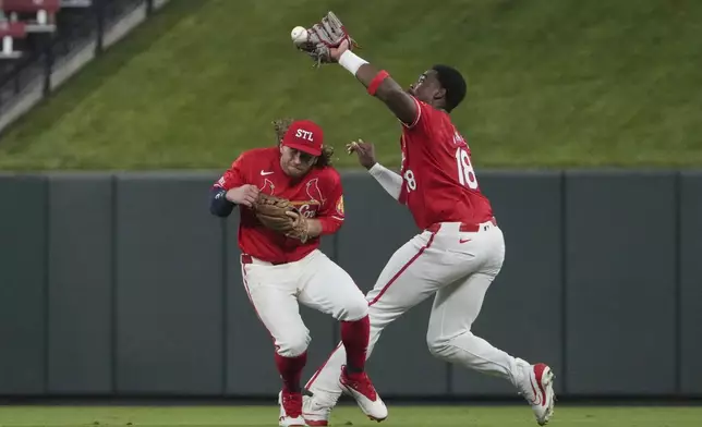 St. Louis Cardinals second baseman Brendan Donovan, left, nearly collides with right fielder Jordan Walker as Walker catches a fly ball by Cincinnati Reds' Connor Joe for an out during the eighth inning of a baseball game Friday, June 20, 2025, in St. Louis. (AP Photo/Jeff Roberson)