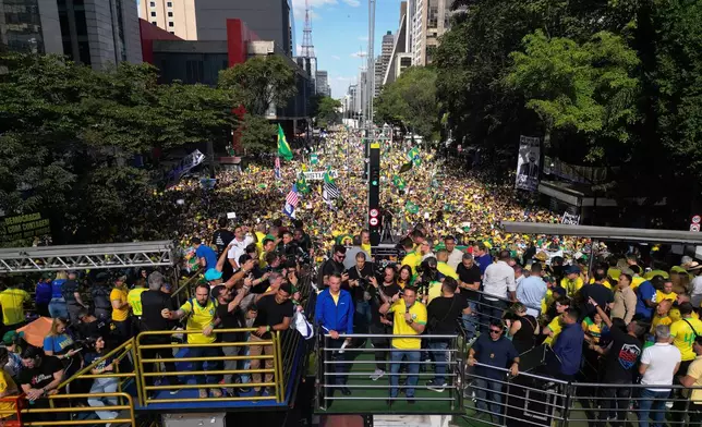 Former President Jair Bolsonaro, in blue, takes part in a protest against his Supreme Court trial, in which he is accused of involvement in a 2022 coup attempt, in Sao Paulo, Sunday, June, 29, 2025. (AP Photo/Ettore Chiereguini)