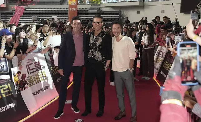 FILE - Actor Hugh Jackman, left, Ryan Reynolds and director Shawn Levy, right, pose during the red carpet event to promote their latest movie "Deadpool &amp; Wolverine" in Seoul, South Korea, July 4, 2024. (AP Photo/Ahn young-joon, File)