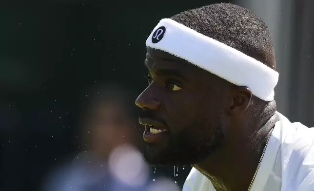 Frances Tiafoe, of the U.S., rests as droplets of sweat fall from his chin during his first round men's single match against Elmer Moller of Denmark at the Wimbledon Tennis Championships in London, Monday, June 30, 2025. (AP Photo/Kirsty Wigglesworth)