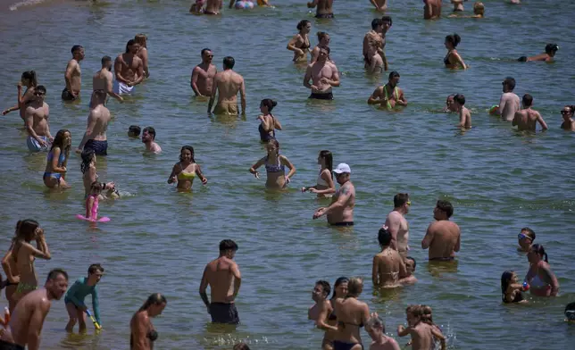 Swimmers cool off in the water at a beach on a hot day in Barcelona, Spain, Saturday, June 28, 2025. (AP Photo/Emilio Morenatti)