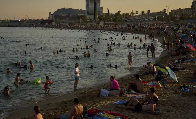 Swimmers cool off in the water at a beach on a hot day in Barcelona, Spain, Sunday, June 29, 2025. (AP Photo/Emilio Morenatti)