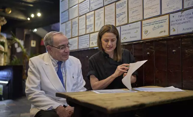 Irene Guinales, right, and Pedro Guinales del Valle, owners and managers of Casa Pedro restaurant, review documents regarding the restaurant's opening date in Madrid, Spain, on May 16, 2025. (AP Photo/Manu Fernandez)
