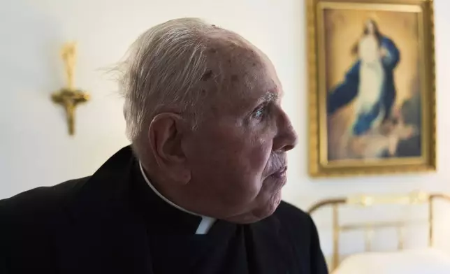 The Rev. James Kelly looks out his apartment window in the Normandy Farms Estates retirement community in Blue Bell, Pa., on Wednesday, June 18, 2025. (AP Photo/Luis Andres Henao)
