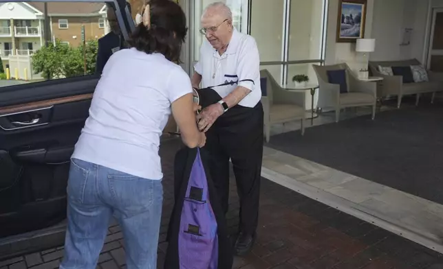 The Rev. James Kelly takes off his Roman collar and gets ready to go to a doctor’s appointment in Blue Bell, Pa., on Wednesday, June 18, 2025. (AP Photo/Luis Andres Henao)