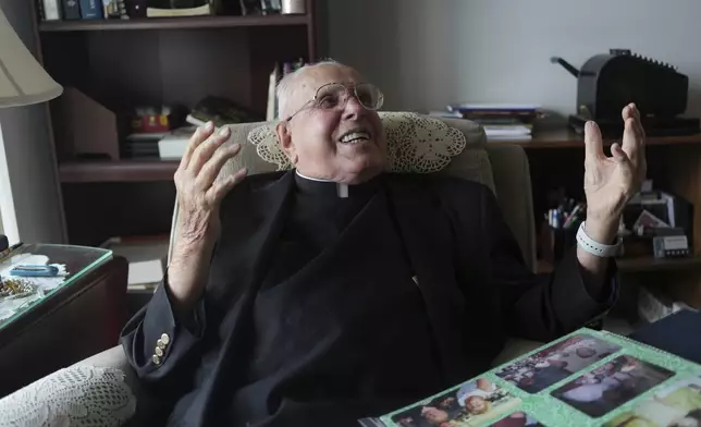 The Rev. James Kelly laughs during an interview at his apartment in the Normandy Farms Estates retirement community in Blue Bell, Pa., on Wednesday, June 18, 2025. (AP Photo/Luis Andres Henao)