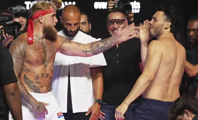 Jake Paul, left, and Julio Cesar Chavez Jr., right, taunt each other following a weigh-in ahead of their cruiserweight boxing match, Friday, June 27, 2025, in Anaheim, Calif. (AP Photo/Chris Pizzello)