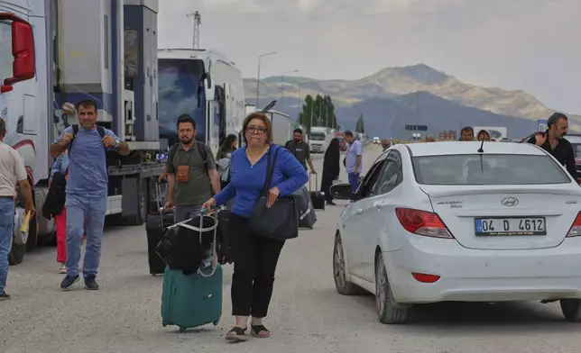 Iranians arrive to cross into Iran at Gurbulak Bazargan border post, in Gurbulak, Turkey, Monday, June 16, 2025. (AP Photo/Kadir Cesur)