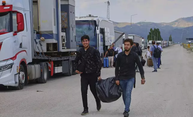 Iranians arrive to cross into Iran at Gurbulak Bazargan border post, in Gurbulak, Turkey, Monday, June 16, 2025. (AP Photo/Kadir Cesur)