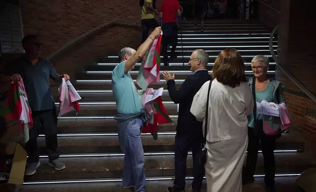 A man receives a Basque flag, or "Ikurrina," ahead of the Nations League match between the Euskadi national team and the Spanish national team at the Jai Alai fronton in Guernica-Luno, northern Spain, Friday, June 6, 2025. (AP Photo/Miguel Oses)