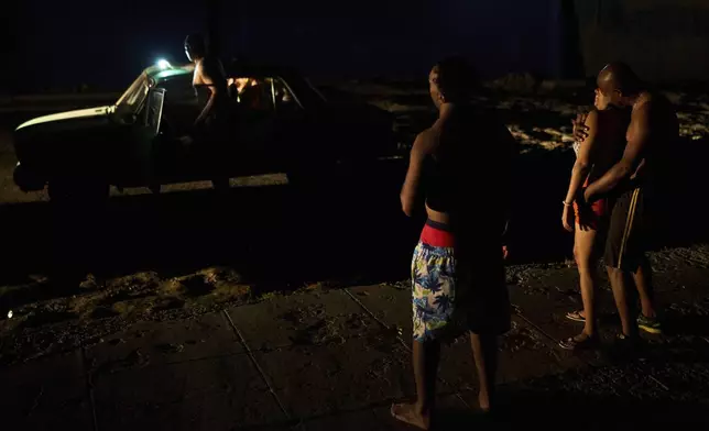 People pass the time in the street during a blackout in Havana, Cuba, Wednesday, May 28, 2025. (AP Photo/Ramon Espinosa)