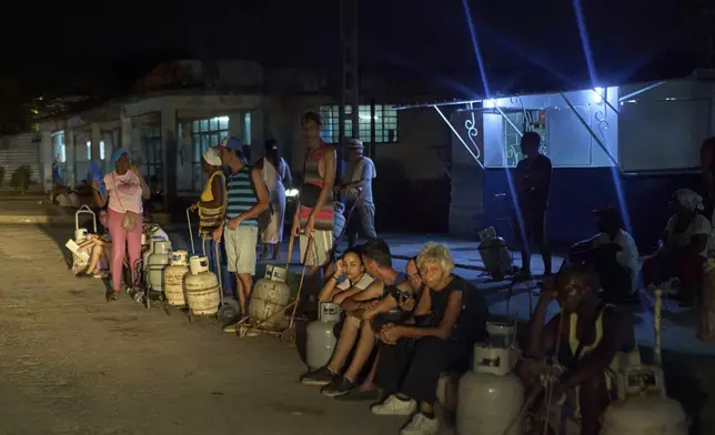 People wait to refill their cooking gas canisters in Alamar, Havana province, Cuba, late Saturday, May 31, 2025. (AP Photo/Ramon Espinosa)