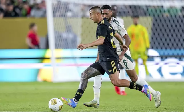 Mexico midfielder Roberto Alvarado (25) dribbles the ball past Saudi Arabia midfielder Ali Alhassan (6) during a CONCACAF Gold Cup quarterfinal soccer match, Saturday, June 28, 2025, in Glendale, Ariz. (AP Photo/Samantha Chow)