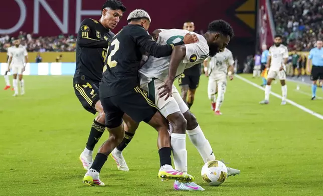 Saudi Arabia forward Feras Albrikan (9) traps the ball while pressured by Mexico defender Julián Araujo (22) and Mexico midfielder Edson Álvarez (4) during a CONCACAF Gold Cup quarterfinal soccer match, Saturday, June 28, 2025, in Glendale, Ariz. (AP Photo/Samantha Chow)