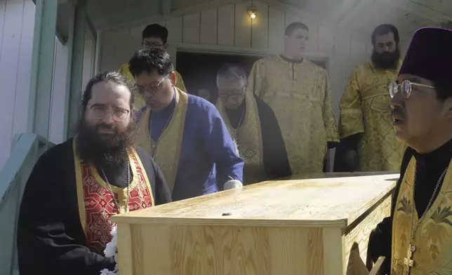 Church officials move the relics, or remains, of Matushka Olga Michael from the church to a nearby graveyard for one last ceremony before her canonization ceremony to become St. Olga, in Kwethluk, Alaska, on June 19, 2025. (AP Photo/Mark Thiessen)