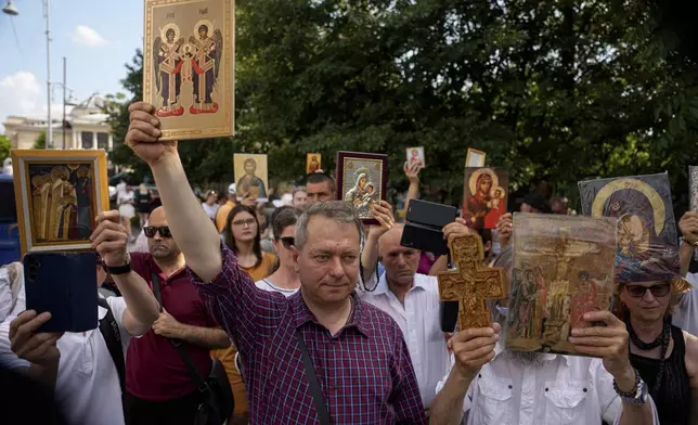 Opponents of gay rights hold religious icons during the Bucharest Pride Parade in Bucharest, Romania, Saturday, June 7, 2025. (AP Photo/Andreea Alexandru)
