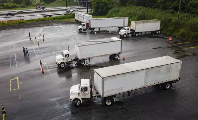 Trucking students practice reverse parking in training trucks at the Driving Academy on Thursday, Sept. 14, 2017 in Linden, N.J., where students prepare to obtain a Commercial Driver’s License (CDL) with multilingual instructors. (AP Photo/Angelina Katsanis)