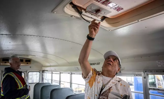 Manuel Castillo, right, one of the Spanish-speaking truck driving students, runs through a safety check with guidance from instructor Paul Cuartas on a training school bus at the Driving Academy on Tuesday, June 10, 2025 in Linden, N.J. (AP Photo/Angelina Katsanis)